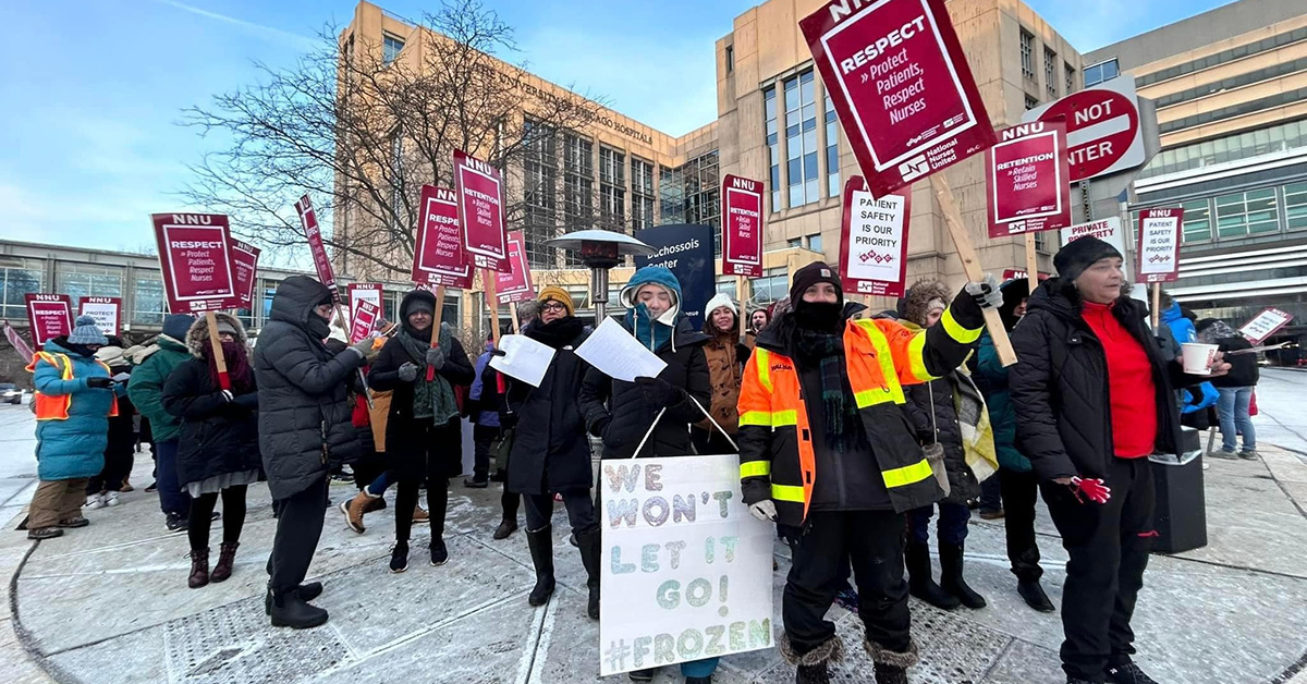 Group of nurses picketing outside of hospital, dressed for cold weather