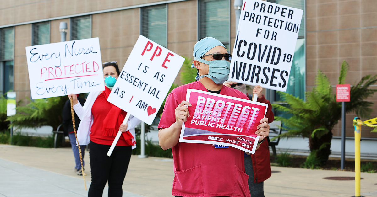 Nurses protesting for PPE holding signs "PPE is as essential as I am", "Proper protection for Covid-19 Nurses", "Every Nurse Protected Every Time", "Protect Nurses, Patients, Public Health"